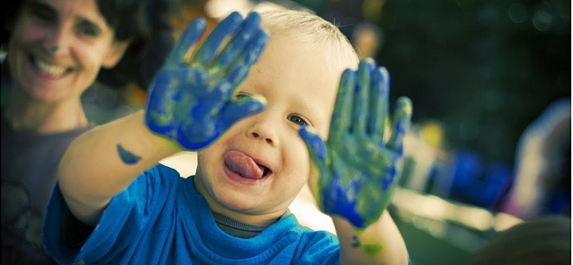 Játszó gyermek festékes kézzel